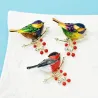 A bird sitting on a branch - crystal brooch