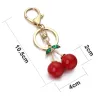 Porte-clés en forme de cerise rouge - avec cristal vert