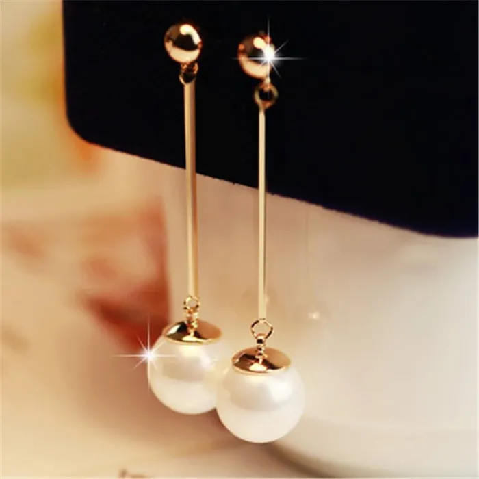 Boucles d'oreilles longues dorées avec une perle