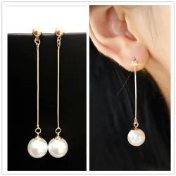 Boucles d'oreilles longues dorées avec une perle