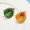Broche com besouro e folha