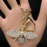 Chaveiro dourado com uma abelha de cristal